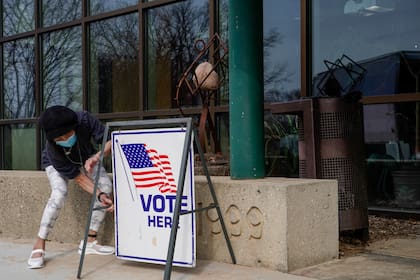 ARCHIVO- La trabajadora electoral Pranee Sheskey coloca un cartel fuera del Warner Park Community Recreation Center para el primer día de votación anticipada el martes 21 de marzo de 2023, en Madison, Wisconsin. (AP Foto/Morry Gash, Archivo)
