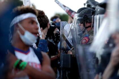 ARCHIVO - Manifestantes enfrentan a agentes del Departamento de Policía en Austin durante una movilizacion en el centro de la ciudad, en Texas, el 4 de junio de 2020, para protestar por la muerte de George Floyd. (AP Foto/Eric Gay)