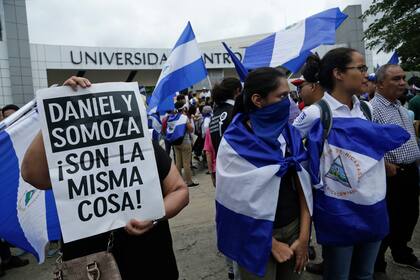 ARCHIVO - Manifestantes protestan fuera de la jesuita Universidad Centroamericana de Nicaragua, UCA, en reclamo del 6 % de su presupuesto nacional en Managua, Nicaragua, el 2 de agosto de 2018. Los jesuitas anunciaron el miércoles 16 de agosto de 2023 que el gobierno nicaragüense ordenó la confiscación de bienes de la UCA, considerada la más importante y prestigiosa universidad privada del país. (AP Foto/Arnulfo Franco, Archivo)