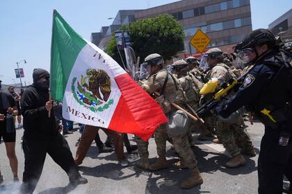 ARCHIVO – Manifestantes se enfrentan con las autoridades en el centro de Los Ángeles, el domingo 8 de junio de 2025, tras las protestas contra las redadas migratorias de la noche anterior. (AP Foto/Jae Hong, Archivo)