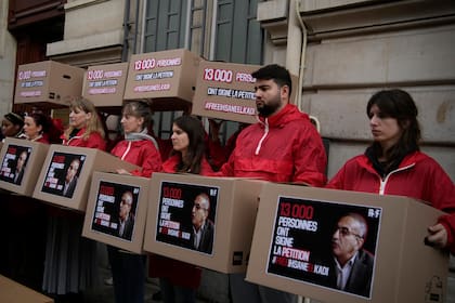 ARCHIVO - Manifestantes se manifiestan ante la embajada argelina en Francia para reclamar la liberación del periodista argelino Ihsane El Kadi, en París, Francia, el 30 de marzo de 2023. (AP Foto/Christophe Ena, Archivo)