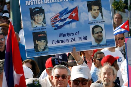 ARCHIVO - Mario de la Peña lleva un cartel con las fotos de los cuatro pilotos derribados por Migs c