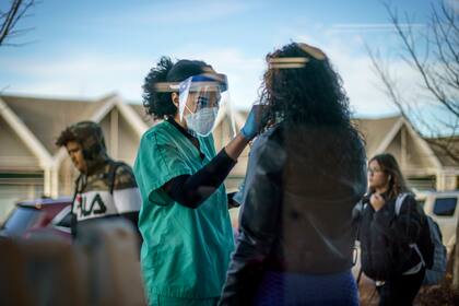 ARCHIVO - Maya Goode, una técnica en COVID-19, realiza una prueba a Jessica Sanchez afuera de la Farmacia Asthenis de Providence, Rhode Island, el 7 de diciembre de 2021. (AP Foto/David Goldman, archivo)