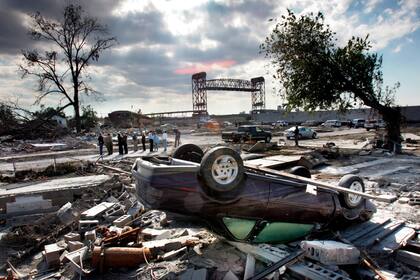 ARCHIVO - Miembros de la Autoridad de Recuperación de Luisiana recorren la zona del Lower 9th Ward de Nueva Orleans el miércoles 26 de octubre de 2005, luego de que gran parte de esa región quedó destruida al romperse el dique en el Canal Industrial durante los huracanes Katrina y Rita. (AP Foto/Robert F. Bukaty, Archivo)