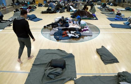 ARCHIVO - Migrantes descansan en un refugio en Denver, 6 de enero de 2023