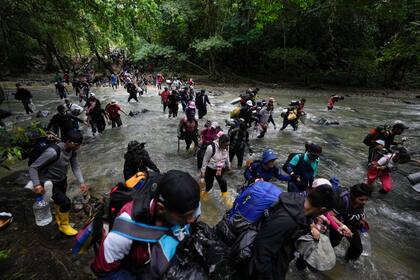 Archivo.- Migrantes, en su mayoría venezolanos, cruzan un río en la selva del Darién el 15 de octubre de 2022, en un recorrido de Colombia a Panamá, con la esperanza de seguir luego su viaje hacia Estados Unidos