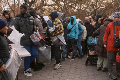 ARCHIVO - Migrantes toman mantas cerca de un Centro de Ayuda a Migrantes en la escuela primaria St. Brigid, el martes 5 de diciembre de 2023, en Nueva York. (AP Foto/Andres Kudacki, Archivo)