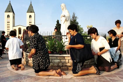 ARCHIVO - Mujeres católicas bosnias rezan durante el feriado de la Asunción en Medjugorje, unos 120 kilómetros (75 millas) al sur de la capital bosnia, Sarajevo, el 15 de agosto de 2000. (AP Foto/Hidajet Delic, Archivo)