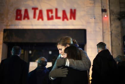 ARCHIVO - Mujeres se abrazan ante la sala de conciertos Bataclan en París, el 13 de noviembre de 2016