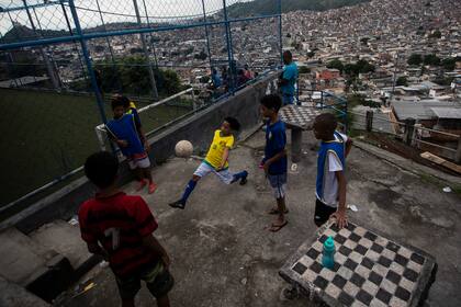 ARCHIVO - Niños juegan fútbol mientras esperan un programa de entrenamiento de fútbol callejero dirigido por la organización no gubernamental Street Child United Brazil en la favela Complexo da Penha, en Río de Janeiro, Brasil, el 29 de abril de 2023. (AP Foto/Bruna Prado, Archivo)
