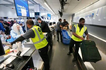 ARCHIVO - Pasajeros dejan su equipaje en el mostrador de United Airlines en la Terminal C del Aeropuerto Internacional George Bush, el jueves 21 de diciembre de 2023, en Houston. (Brett Coomer/Houston Chronicle via AP, Archivo)