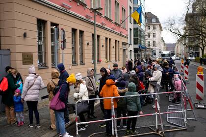 Archivo - Personas de Ucrania, la mayoría de ellos refugiados que huyen de la guerra, hacen fila frente al departamento consular de la embajada ucraniana en Berlín, Alemania, el 6 de abril de 2022. (AP Foto/Markus Schreiber, Archivo)