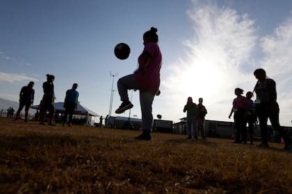 ARCHIVO - Personas juegan fútbol en un centro de detención del gobierno de EE.UU. para niños migrantes, en Carrizo Springs, Texas, el 9 de julio de 2019 (AP Foto/Eric Gay/Archivo)