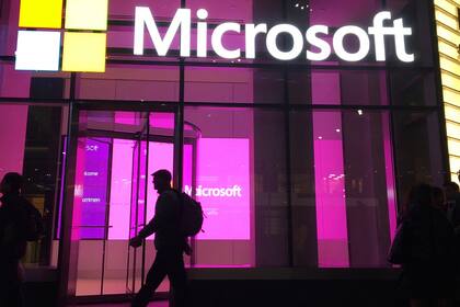 ARCHIVO - Personas pasan ante una oficina de Microsoft en Nueva York, el 10 de noviembre de 2016. (AP Foto/Swayne B. Hall, Archivo)