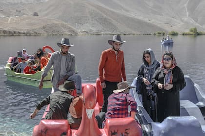 (ARCHIVO) Personas sentadas en barcas de remos durante un paseo por el lago Band e-Amir, en la provincia de Bamiyán, el 4 de octubre de 2021. Los observadores de los derechos humanos condenaron el 28 de agosto de 2023 la prohibición impuesta a las mujeres de visitar uno de los parques nacionales más populares de Afganistán, el último freno que excluye a las mujeres de la vida pública bajo el gobierno talibán. El Ministerio de Moralidad del gobierno talibán cerró el fin de semana el parque nacional Band-e-Amir a las mujeres, alegando que las visitantes no se cubrían con la vestimenta islámica adecuada. (Foto de Bulent KILIC / AFP) / XGTY