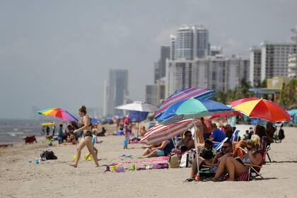 ARCHIVO - Personas sentadas en la playa Hollywood Beach, el 2 de julio de 2020, en Hollywood, Florida. (AP Foto/Lynne Sladky, Archivo)