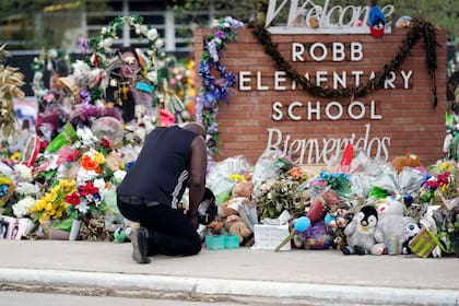 ARCHIVO - Reggie Daniels rinde sus condolencias en un monumento en la Escuela Primaria Robb en Uvalde, Texas, el 9 de junio de 2022, en honor a los dos maestras y 19 estudiantes muertos en el tiroteo en la escuela el 24 de mayo. (AP Foto/Eric Gay, Archivo)