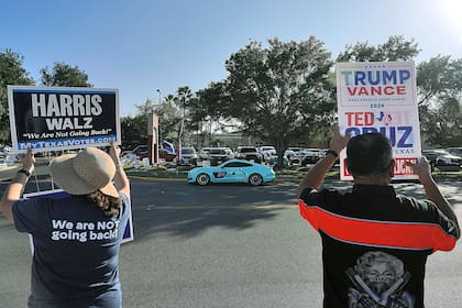 ARCHIVO - Simpatizantes de la candidata presidencial demócrata, la vicepresidenta Kamala Harris, y del candidato presidencial republicano, el expresidente Donald Trump, hacen campaña a las puertas de un colegio electoral, el 5 de noviembre de 2024, en McAllen, Texas. (Joel Martinez/The Monitor via AP, Archivo/The Monitor via AP)