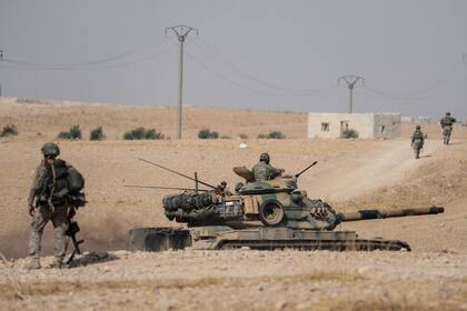 ARCHIVO - Tanques y tropas turcas están apostados cerca de Manbij, Siria, 15 de octubre de 2019. (Ugur Can/DHA via AP, File)