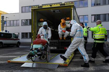 Archivo - Trabajadores de la salud transportan a un enfermo de COVID-19 en Ceska Lipa, República Checa, el jueves 18 de marzo de 2021. (AP Foto/Petr David Josek, Archivo)