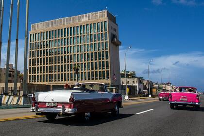 ARCHIVO - Turistas se desplazan en automóviles convertibles clásicos en el Malecón junto a la embajada de Estados Unidos, el 3 de octubre de 2017, en La Habana, Cuba. (AP Foto/Desmond Boylan, archivo)