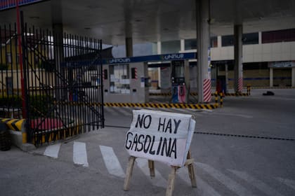 ARCHIVO - Un cartel advierte sobre la falta de gasolina en una estación de combustible después de varios días de bloqueos de carreteras por parte de partidarios del expresidente Evo Morales que afectaron el suministro de combustible y alimentos en La Paz, Bolivia, el lunes 21 de octubre de 2024. (AP Foto/Juan Karita, Archivo)