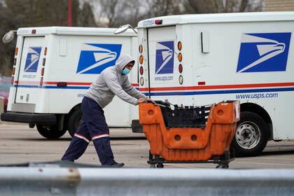 Archivo - Un empleado del Servicio Postal de Estados Unidos (USPS, por sus siglas en inglés) trabaja fuera de la oficina de correos en Wheeling, Illinois, el 3 de diciembre de 2021. (AP Foto/Nam Y. Huh, Archivo)