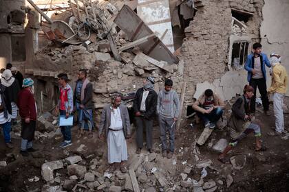 ARCHIVO - Un grupo de personas se reúnen en un complejo impactado por un ataque aéreo en Saná, Yemen, el sábado 11 de noviembre de 2017. (AP Foto/Hani Mohammed)