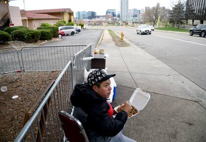 Archivo.- Un hombre come fuera de un motel para migrantes en Denver, Colorado, el jueves 18 de abril de 2024 (AP Foto/Thomas Peipert)