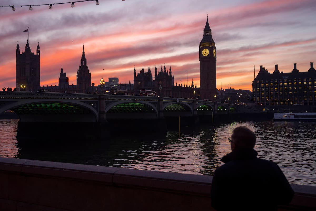 ARCHIVO - Un hombre pasea por la orilla sur del río Támesis, con la Torre Elizabeth, más conocida como Big Ben, y el Palacio de Westminster de fondo, en Londres, el 17 de enero de 2023. (AP Foto/Kin Cheung, archivo)