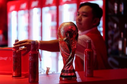 ARCHIVO - Un mesero retira botellas de Budweiser de un bar durante una fiesta de la federación de fútbol de Estados Unidos, el domingo 20 de noviembre de 2022, en Doha, Qatar. (AP Foto/Ashley Landis)