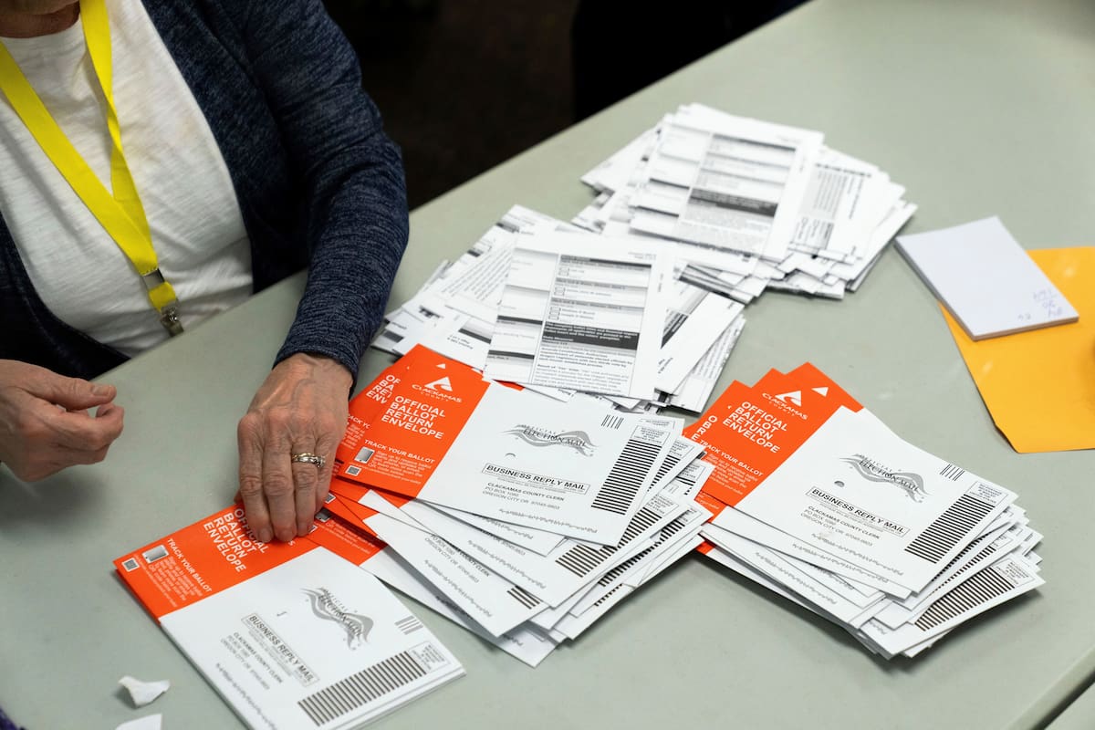ARCHIVO - Un miembro del personal electoral toma una boleta sin abrir durante el proceso de clasific