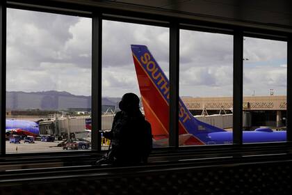 ARCHIVO - Un pasajero camina frente a un avión de Southwest Airlines en el Aeropuerto Internacional de Sky Harbor en Phoenix, el 26 de marzo de 2021. (AP Foto/Sue Ogrocki, Archivo)