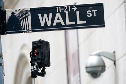 ARCHIVO - Un señalamiento de Wall Street es visto al lado de un equipo de vigilancia afuera de la Bolsa de Valores de Nueva York, el 5 de octubre de 2021, en Nueva York. (AP Foto/Mary Altaffer, archivo)