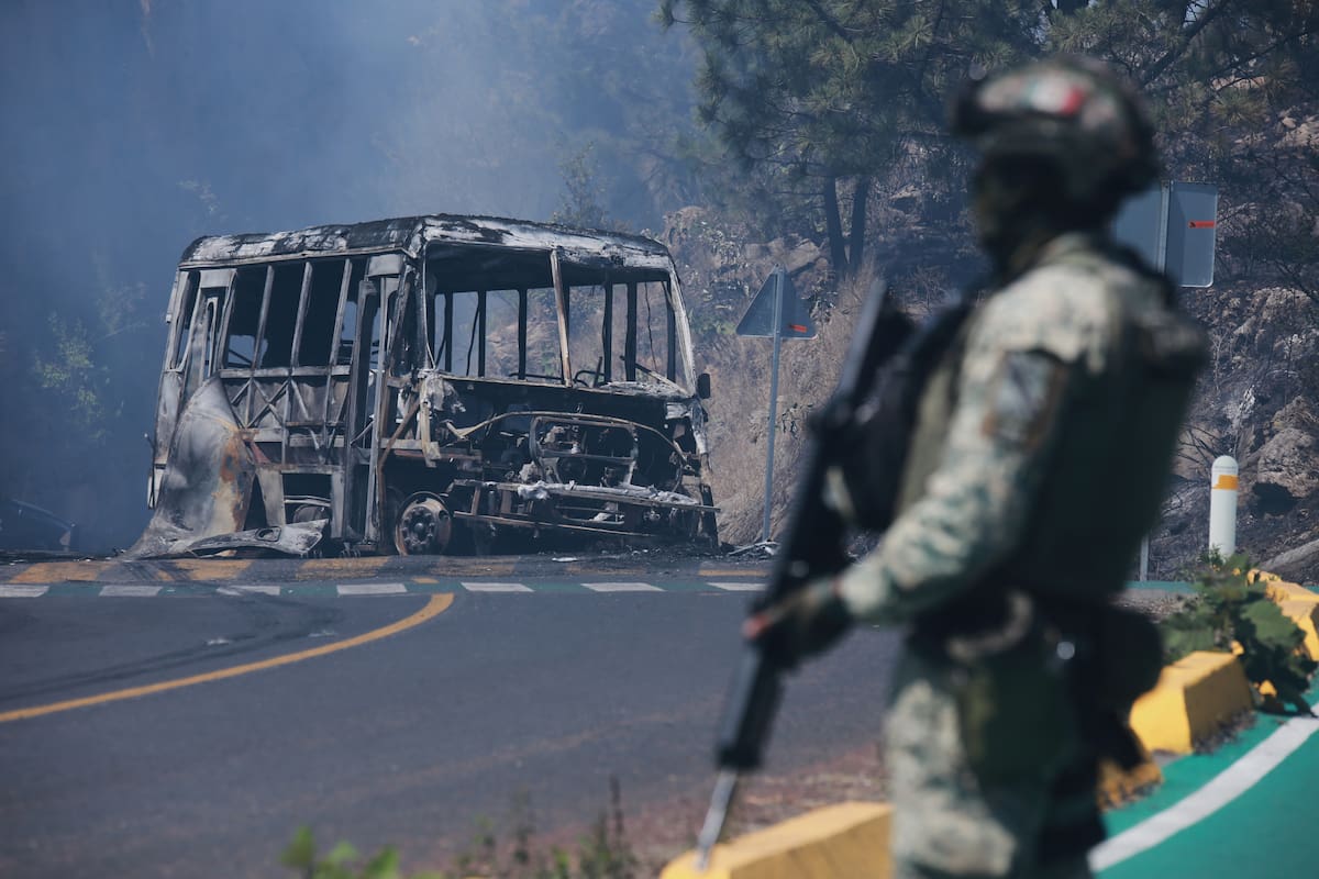 ARCHIVO – Un soldado monta guardia frente a un vehículo en llamas tras ser incendiado en Cointzio, M
