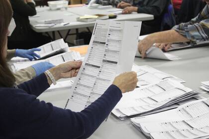 ARCHIVO - Un trabajador electoral examina una papeleta en la oficina electoral del condado de Clackamas el 19 de mayo de 2022, en Oregon City, Oregón. (AP Foto/Gillian Flaccus, Archivo)