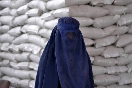 ARCHIVO - Una afgana espera para recibir comida distribuida por un grupo de ayuda humanitaria de Corea del Sur, en Kabul, Afganistán, el 10 de mayo de 2022. (AP Foto/Ebrahim Noroozi, Archivo)