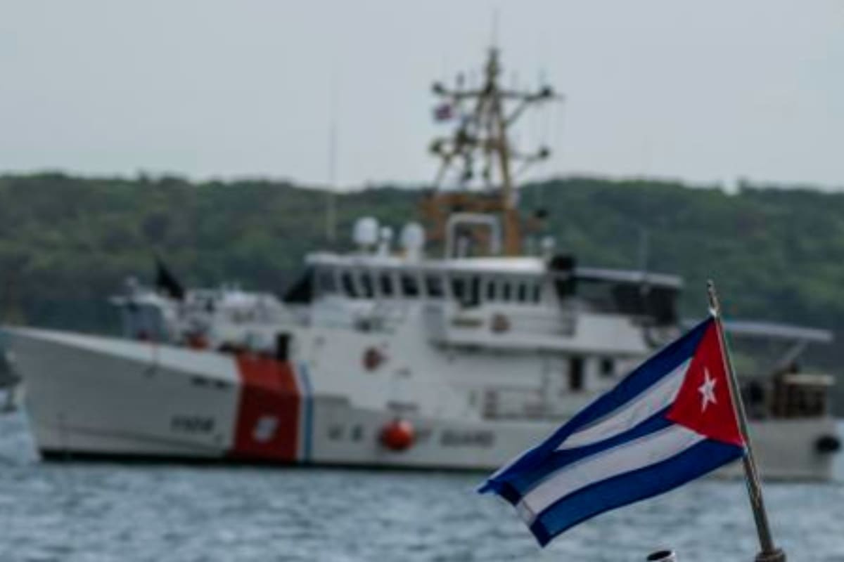 Archivo. Una bandera de Cuba de un bote de patrulla fronteriza de ese país, mientras el barco Charles Sexton de la Guardia Costera de Estados Unidos llega para entregar a cubanos deportados.