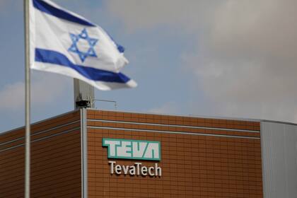 ARCHIVO - Una bandera israelí frente al edificio de la farmacéutica Teva en Neot Hovav, Israel, el 14 de diciembre de 2017. (AP Foto/Tsafrir Abayov, Archivo)