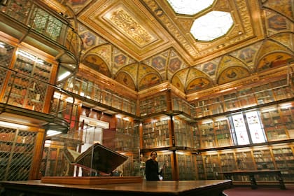 ARCHIVO - Una Biblia latina de 1455 de Johannes Gutenberg y Johann Fust, en primer plano a la izquierda, expuesta dentro de la biblioteca personal de Pierpont Morgan, en la Biblioteca Morgan de Nueva York, el 25 de abril de 2006. Tres veces al año, un curador de la biblioteca da vuelta a la página. (AP Foto/Richard Drew, Archivo)