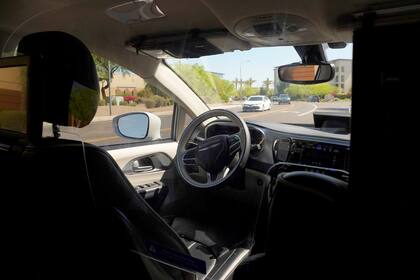 ARCHIVO - Una camioneta de Waymo se mueve por una calle con el asiento del conductor vacío, en un trayecto de vehículo autónomo con pasajeros el 7 de abril de 2021 en Chandler, Arizona. La agencia de seguridad de autopistas de Estados Unidos abrió otra investigación sobre sistemas de conducción automática, esta vez por choques que implicaban a vehículos autónomos Waymo. (AP Foto/Ross D. Franklin, Archivo)