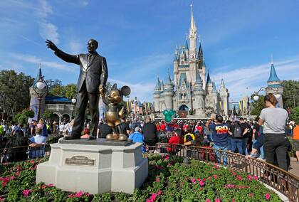 ARCHIVO - Una estatua de Walt Disney y Mickey Mouse frente al Castillo de Cenicienta en el parque de Magic Kingdom en Walt Disney World, en Lake Buena Vista
