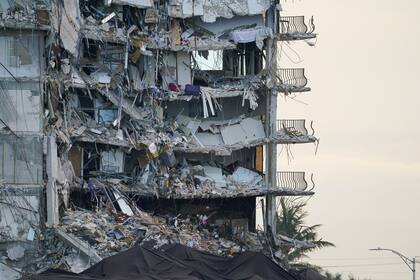 ARCHIVO - Una lona gigante en la parte inferior de la imagen cubre una sección de escombros en el edificio de condominios Champlain Towers South, en Surfside, Florida, el 4 de julio de 2021. (AP Foto/Lynne Sladky, Archivo)