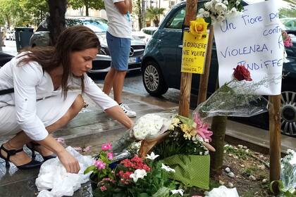 ARCHIVO - Una mujer coloca flores en el lugar donde el vendedor ambulante nigeriano Alika Ogorchukwu fue asesinado, en Civitanova Marche, Italia, el sábado 30 de julio de 2022. (AP Foto/Chiara Gabrielli, archivo)