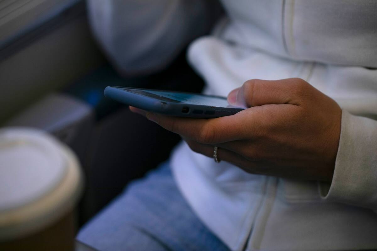 ARCHIVO - Una mujer observa su teléfono en un tren el 18 de mayo de 2021, en Nueva Jersey. (AP Foto/Jenny Kane, archivo)