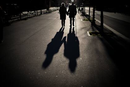 Archivo - Una pareja de adultos mayores camina por un bulevar en Barcelona, el 17 de enero de 2021. (AP Foto/Emilio Morenatti, Archivo)