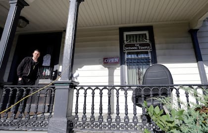 ARCHIVO - Una persona de pie, en el pórtico de las oficinas internacionales del Templo Satánico en Salem, Massachusetts, el 24 de octubre de 2016. (AP Foto/Elise Amendola, Archivo)