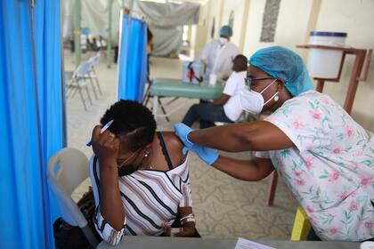 ARCHIVO - Una trabajadora de la salud inyecta a una persona una dosis de la vacuna Moderna para el COVID-19 en el Hospital Saint Damien en Puerto Príncipe, Haití, el 27 de julio de 2021. ​La Organización Panamericana de la Salud dijo el miércoles 8 de diciembre de 2021 que aunque la mayoría de la población del continente americano ya está inmunizada contra el coronavirus, hay seis países -entre ellos Haití y Guatemala- que no alcanzarían a cumplir la meta de 40% de su gente inmunizada en 2021 que fijó la Organización Mundial de la Salud. (AP Foto/Joseph Odelyn, Archivo)