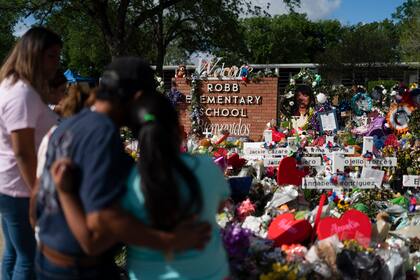 ARCHIVO - Varias personas visitan un monumento conmemorativo el 2 de junio de 2022, el cual fue erigido en honor de las personas asesinadas en la Escuela Primaria Robb, en Uvalde, Texas. (AP Foto/Jae C. Hong, archivo)