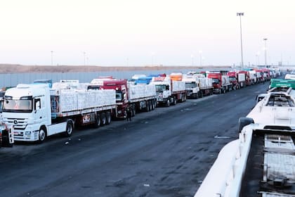 ARCHIVO -Varios camiones que transportan ayuda humanitaria se preparan para cruzar la entrada egipcia del cruce de Rafah, esperando a ser inspeccionados por las autoridades israelíes antes de entrar en la Franja de Gaza, tras un acuerdo entre Israel y Hamás sobre un alto el fuego, el 20 de octubre de 2025. (AP Foto/Mohamed Arafat, Archivo)